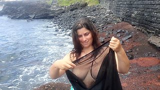 Curvy lady in erotic outfit pleasures herself by the seaside and poses for photoshoot