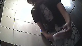 Brunette white cute chick in the toilet room pisses and wipes her pussy