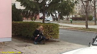Beauty pissing on street behind bushes